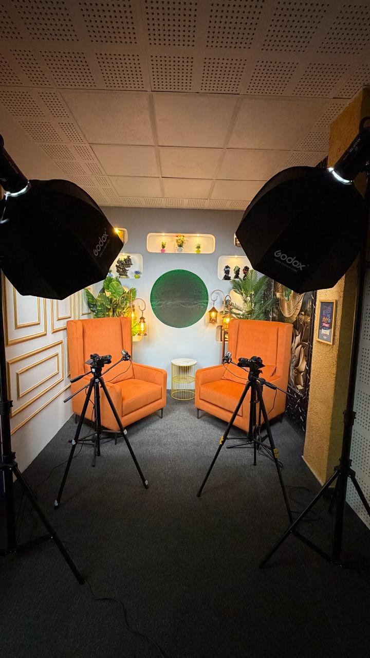 Professional video production studio setup with softbox lights, camera equipment, recording space, and content creation workspace.